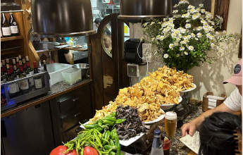 The bar at Ganbara piled with mushrooms and peppers